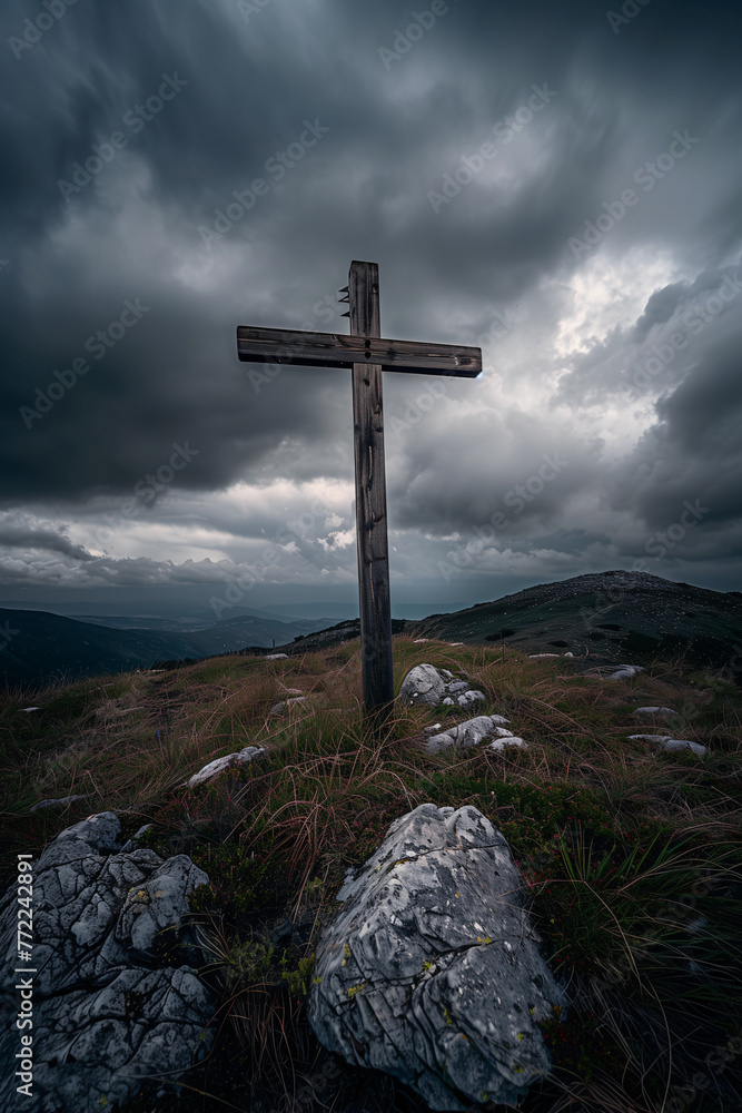 A wooden cross atop the mountain, with dark clouds in the background and a clear sky A wooden cross atop the mountain, with dark clouds in the background and a clear sky