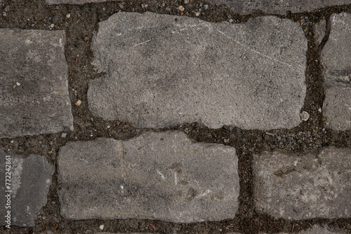 Close-up of the paving stone pavement texture. Cobblestone top view. Old stone sidewalk. Cobble stone road, retro cobble texture. Brick wall. Wallpaper,  background