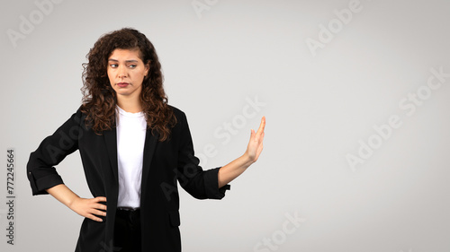 Skeptical businesswoman with hand gesture photo