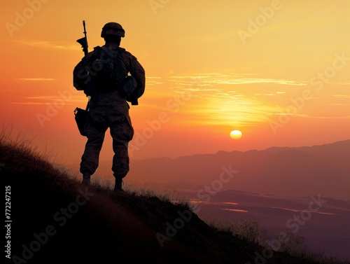 A soldier stands on a hill overlooking a valley with a sunset in the background. Concept of solitude and contemplation, as the soldier is alone in the vast landscape. The sunset adds a touch of warmth