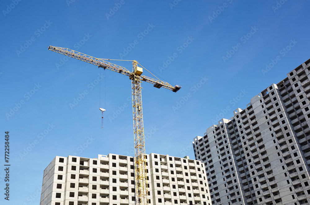 Tower crane building a house. Concrete building under construction. Construction site Tower crane building a house. Concrete building under construction. Construction site