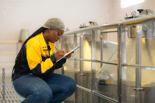 Young woman working in wine cellar at winery
