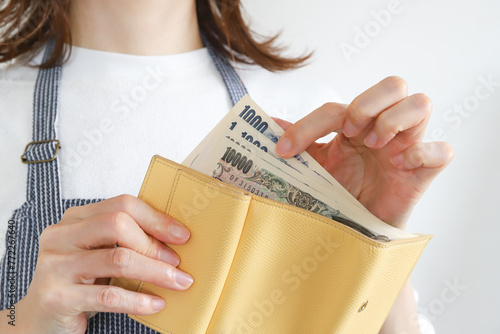財布からお金を出す女性 photo