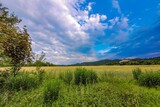 Scenic landscape featuring a green field with hills in the distance. Plavno, Banska Bystrica.