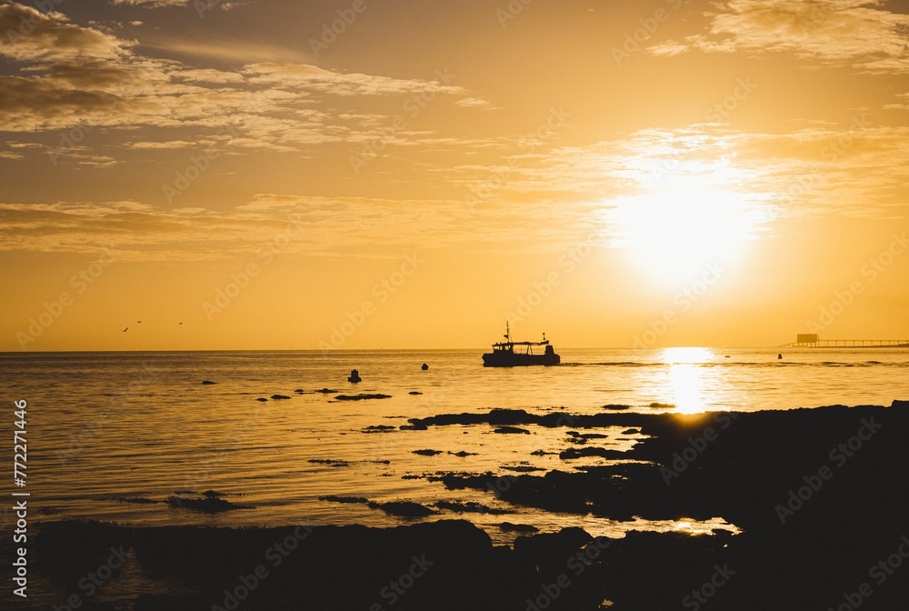 Fishing boat silhouette against sunrise sky in Isle of Wight UK