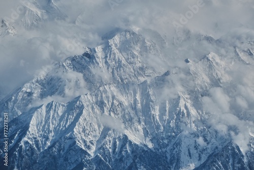 Stunning landscape of majestic snowy Hindu Kush mountain range and billowing white clouds