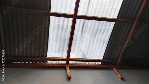 Bright afternoon sunlight enters through the roof of the house with asbestos material and wave-textured UV plastic