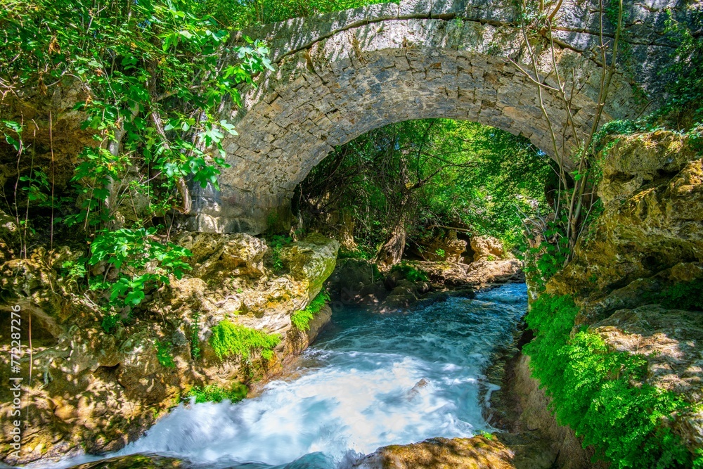 Scenic view of a bridge spanning a body of water near the Kravica Waterfall, Bosnia and Herzegovina Scenic view of a bridge spanning a body of water near the Kravica Waterfall, Bosnia and Herzegovina
