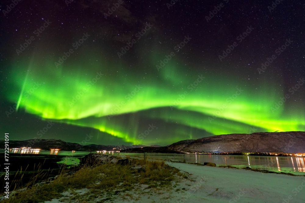 Green auroral light streaking through the sky in the middle of the night