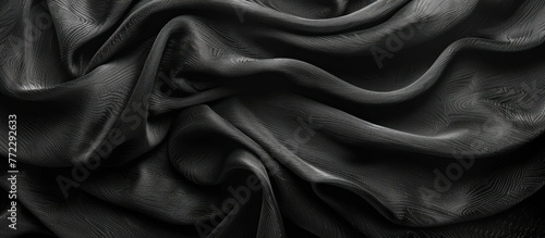 A black and white textured cloth against a black background in monochrome.