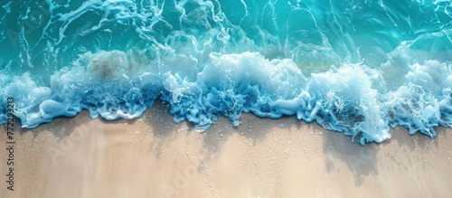 An aerial perspective of a beach with vibrant blue water, showcasing the beauty of the ocean meeting the sandy shoreline.