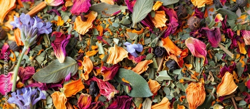 A variety of colorful flowers are strewn across the ground, creating a vibrant and scattered display. Bio herbal tea blend