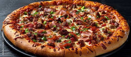 A large, delicious pizza topped with assorted meats sits on a pan placed on a table.