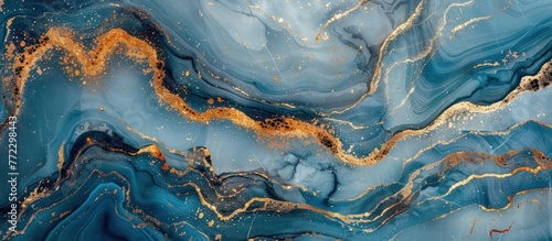 An abstract painting featuring swirls and patterns in gold and blue colors. The colors blend elegantly, creating a visually captivating composition.