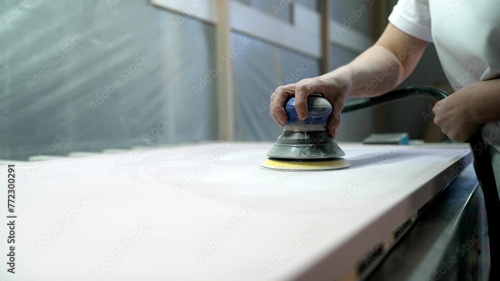Sanding MDF panels using a machine, furniture production. The process of sanding a wooden panel, female hand. Sanding wood plank. Sanding MDF panels using a machine, furniture production. The process of sanding a wooden panel, female hand. Sanding wood plank.