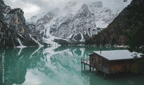 Small wooden hut situated on the edge of the tranquil Braies Lake in Dolomites, Italy.