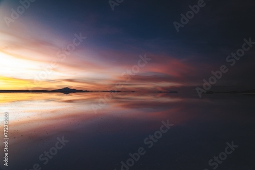 Beautiful sunset mirrored in the tranquil water surface. © Wirestock
