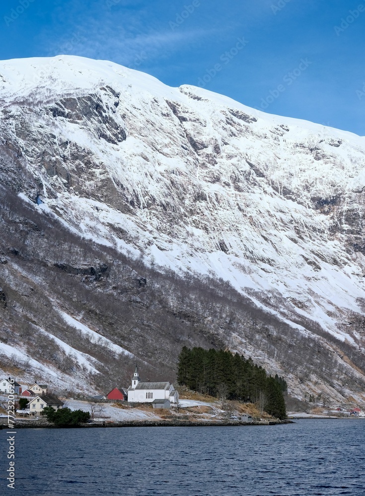 Scenic view of a small Norwegian town located under a snow-capped mountain