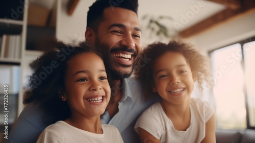 A happy smiling black family, a dad and two cute daughters with curly hair are having fun, enjoying the weekend at home. photo