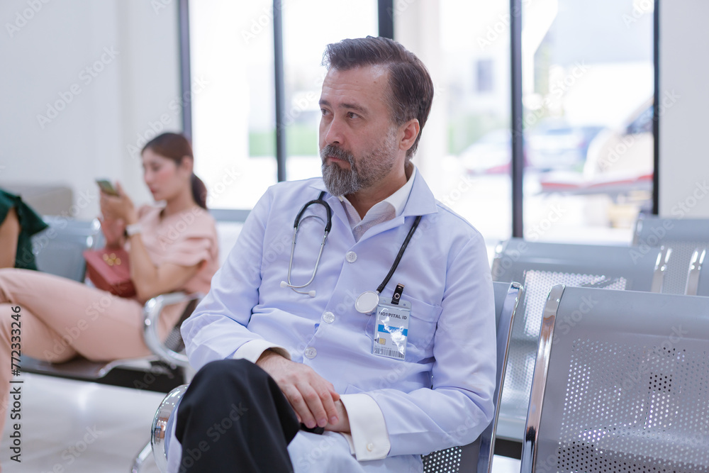 Fototapeta premium Doctor waiting in hospital lobby to meet with general practitioner, sitting in waiting room before consultation. patient in front desk reception.
