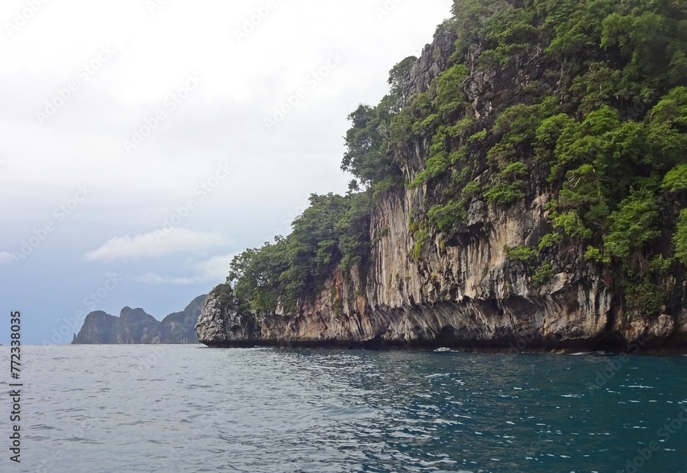 Naklejka premium The serene blue sea is complemented by a majestic mountain towering above it, PHI PHI ISLAND, THAILAND 
