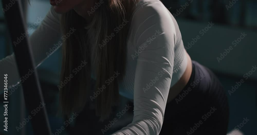 Training glutes, woman doing exercise on training apparatus for buttocks at the gym Training glutes, woman doing exercise on training apparatus for buttocks at the gym