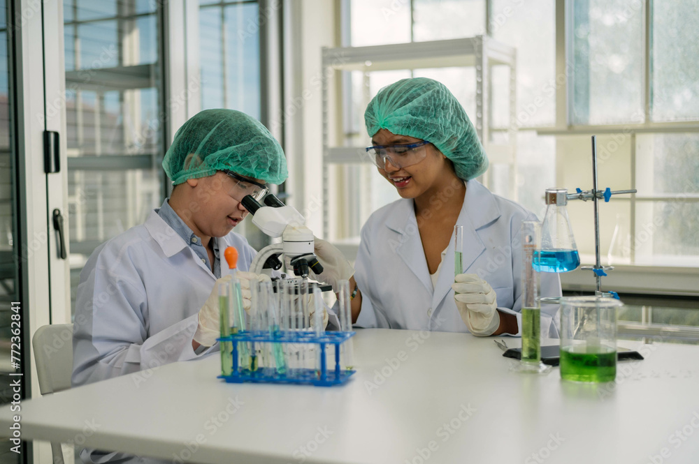 Scientists in protective gear carefully conducting experiments in a well-equipped chemical research laboratory. Scientists in protective gear carefully conducting experiments in a well-equipped chemical research laboratory.