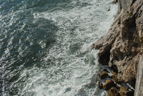 Aerial view of rocks and aquamarine sea waves