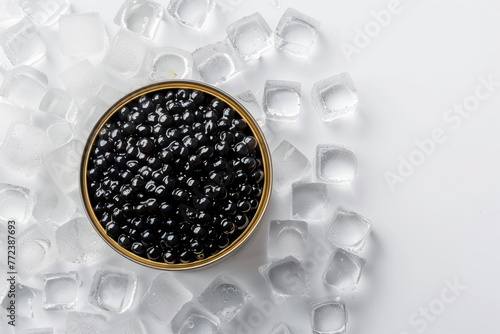 Black caviar in a can standing on ice cubes, top view Isolated on solid white background photo