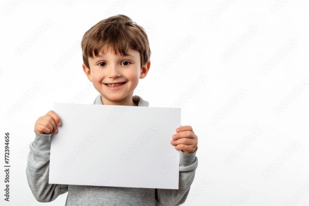 Little smiling boy holding a large white blank card with space for text, graphic or text isolated on white background Little smiling boy holding a large white blank card with space for text, graphic or text isolated on white background