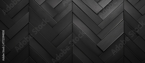 A close up of a dark grey herringbone pattern on a wall