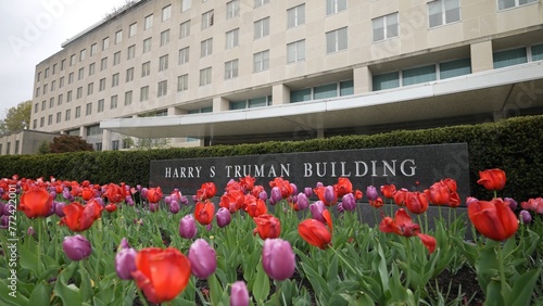 Front turning view of Harry S Truman Department of State building in Washington, DC on an overcast day with tulips in bloom. photo