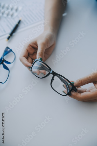 Close-up of Asian female doctor talking with elderly patient showing eyeball model and explaining eye disease in hospital