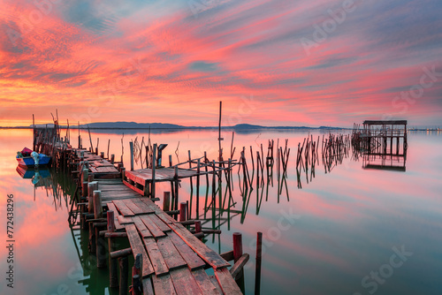 Amazing sunset on the palatial pier of Carrasqueira, Alentejo, Portugal. Wooden artisanal fishing port, with traditional boats on the river Sado. fineart color horizontal photography. photo