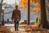 Elderly man walking down the alley in autumn park, generative ai