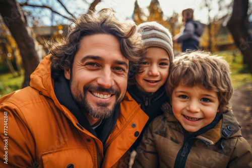 A heartwarming portrait of a father with his two sons during an autumnal day