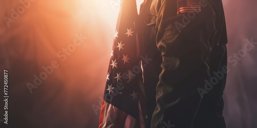 Silhouette of a military person holding the American flag with backlight.