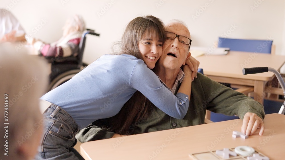 Granddaughter embracing her senior grandfather in a geriatric Granddaughter embracing her senior grandfather in a geriatric