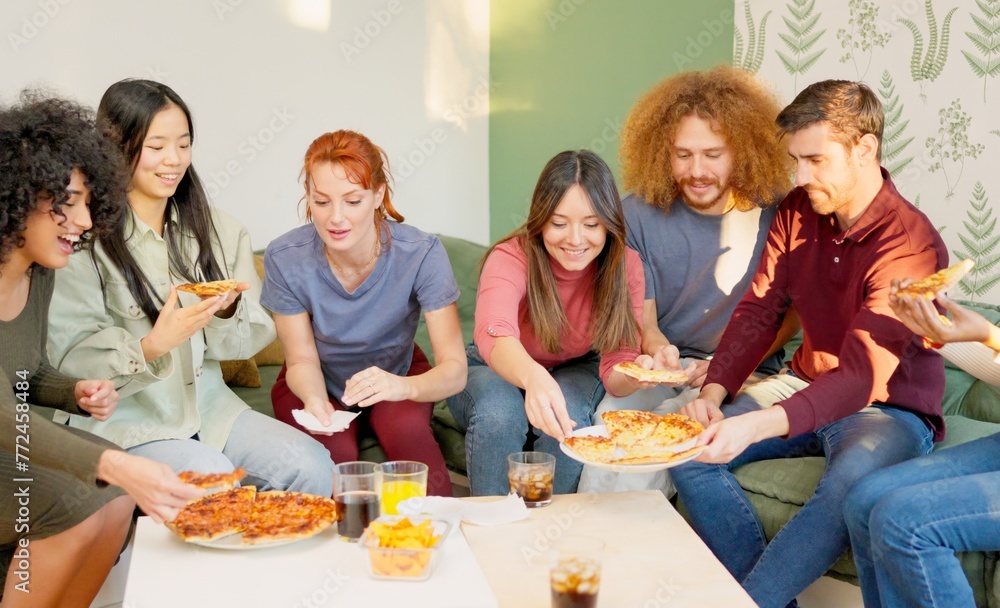 Friends chilling and smiling eating pizza together at home Friends chilling and smiling eating pizza together at home