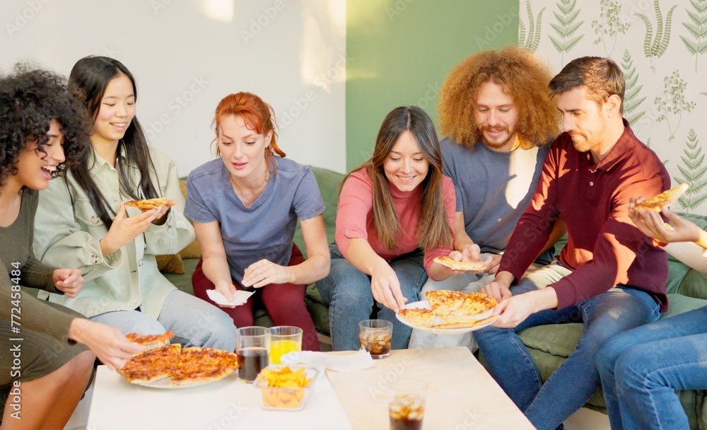 Friends chilling and smiling eating pizza together at home