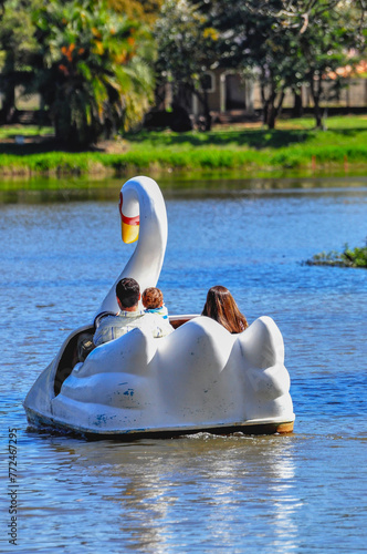 Family fun with a couple and their son with a goose-shaped pedal boat in a park pond in a city in the interior of Minas Gerais