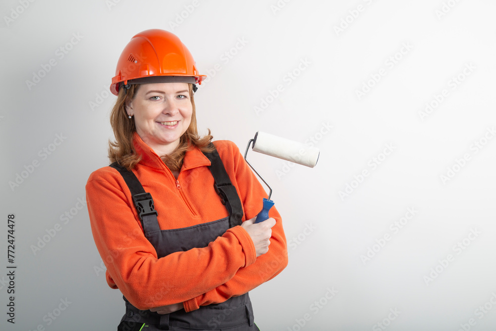 A painter girl with a roller for painting walls.. Painting the walls of the house. A painter girl with a roller for painting walls.. Painting the walls of the house.