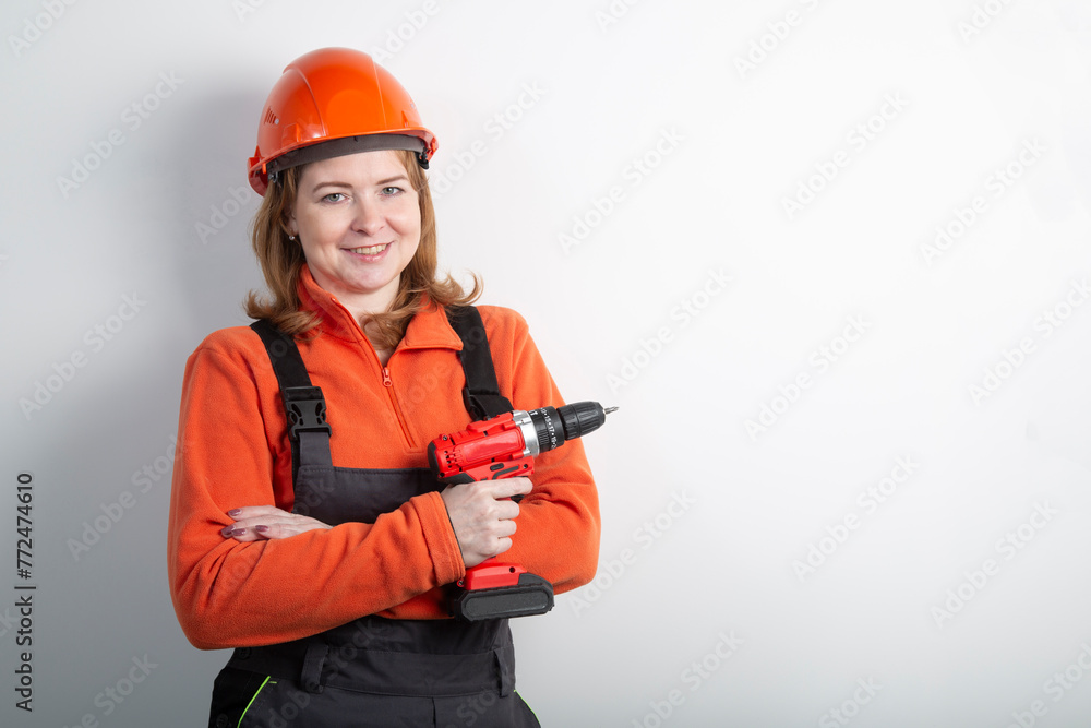 A portable cordless drill in the hands of a girl.A tool for the job . A portable cordless drill in the hands of a girl.A tool for the job .