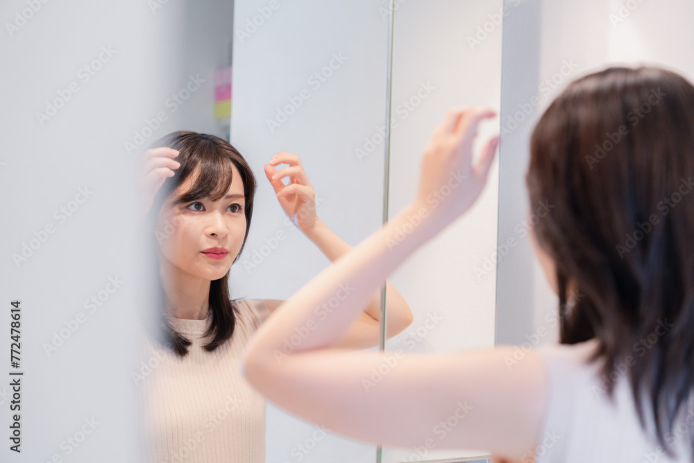 Fototapeta premium 朝の身支度をする若い女性