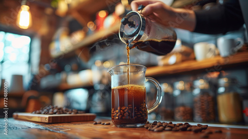 Pouring coffee into glass jug on a wood table