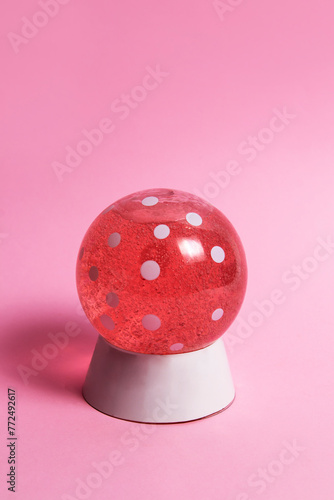 Pink snow globe with dots on pink background