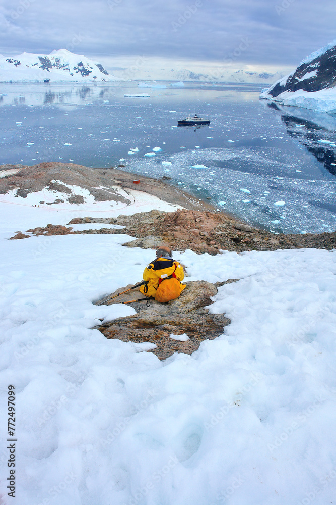 Naklejka premium Tourists visiting Antarctica among snow and penguins