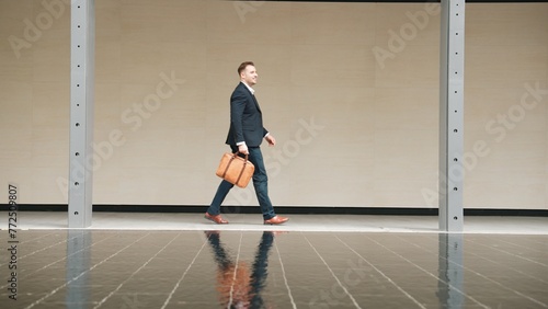 Side view of business people holding suitcase and walking to workplace along the street in urban city. Professional project manager going to meeting while wearing formal suit walk at outdoor. Urbane. © Summit Art Creations