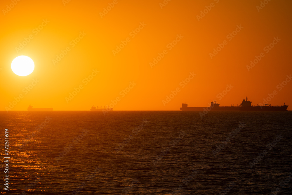 Ocean sunset with ship silhouettes 