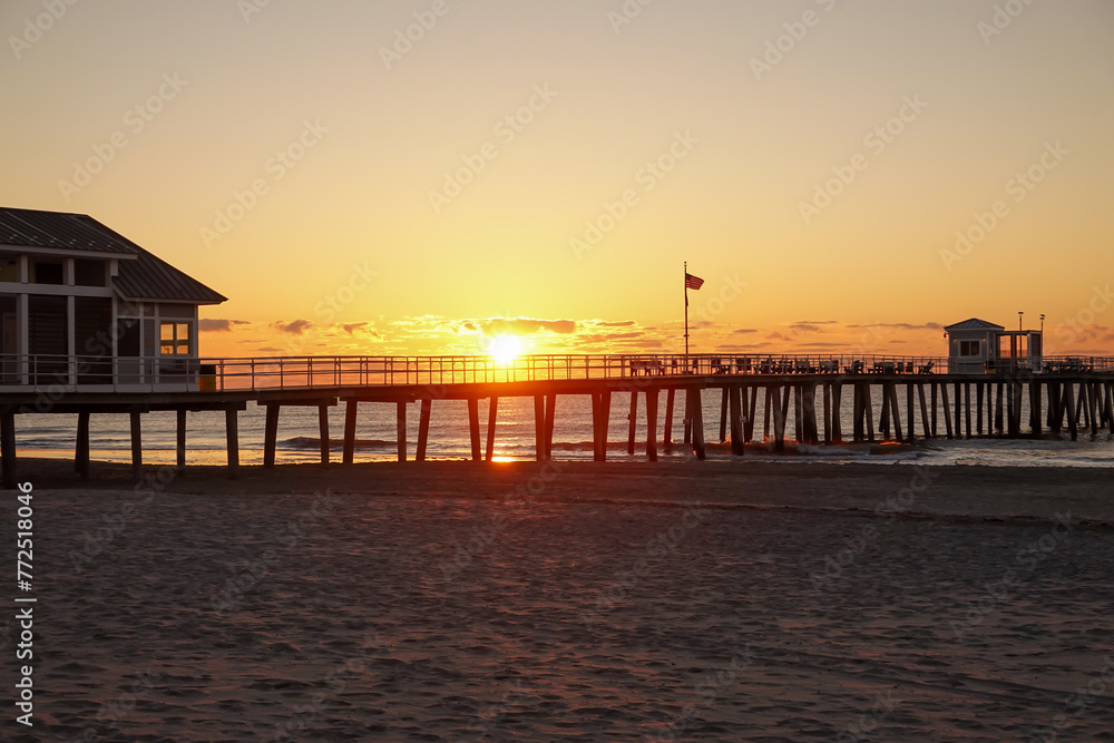 Early morning dramatic sunrise over the ocean and long pier